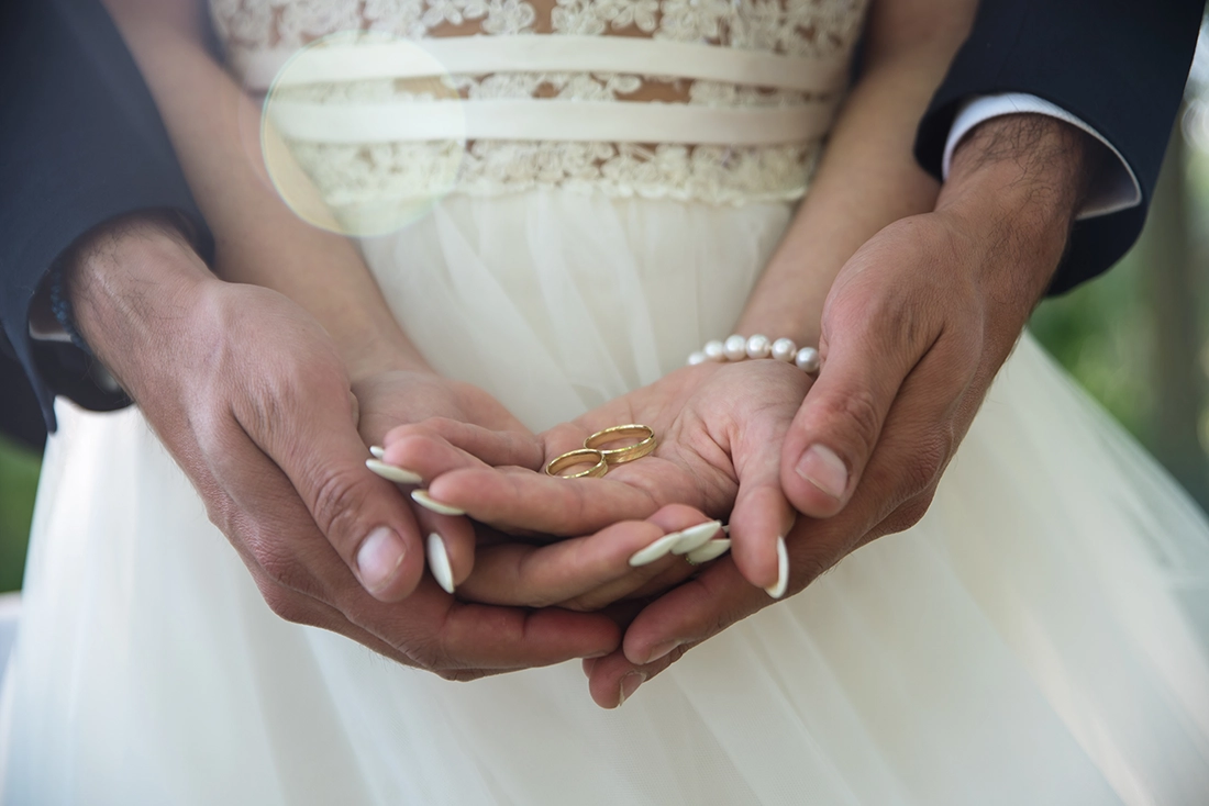 Alianças de casamento nas mãos dos noivos